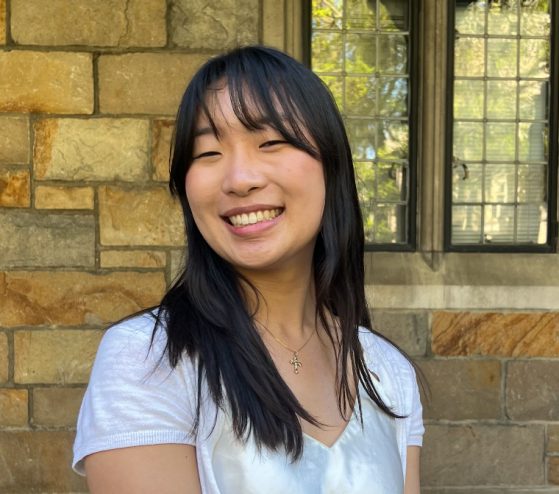 female in white shirt smiling at camera