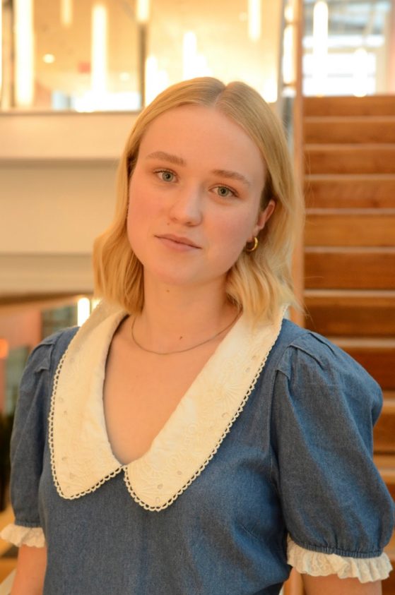 female in blue shirt gazing at camera