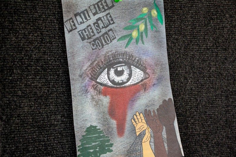 handmade art with bleeding eye and outstretched arms on different colors reads "We all bleed the same color."