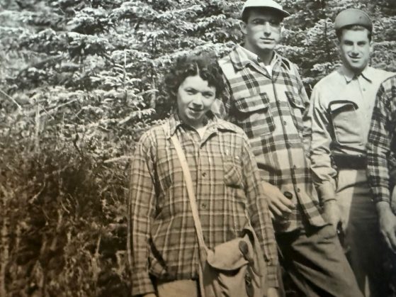 Black and white photo of woman in front of trees