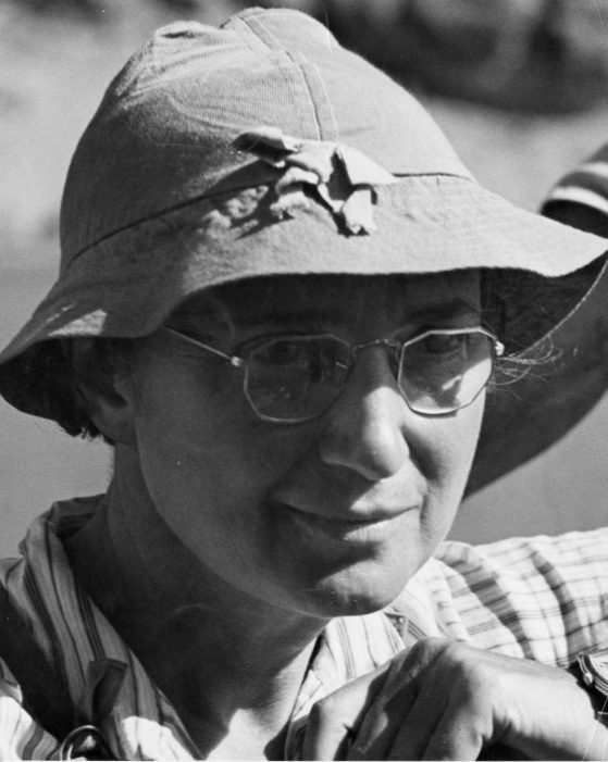 Woman's head, wearing a hat and glasses