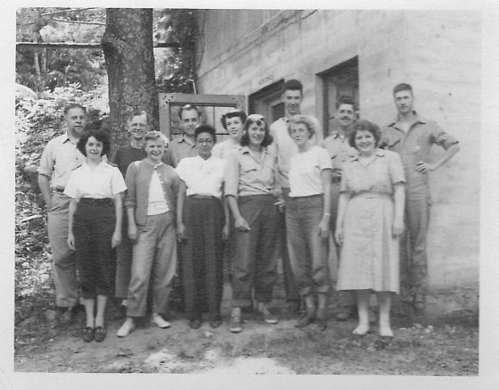 Black and white photo of a group in front of a building