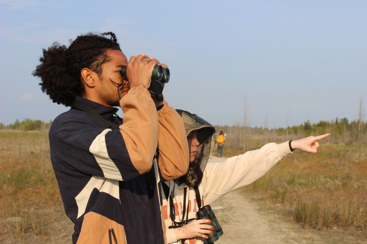 Person looking through binoculars outside