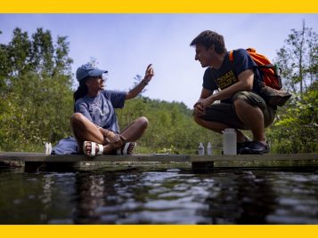 Two students on a boardwalk over water