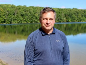 Man standing along lake