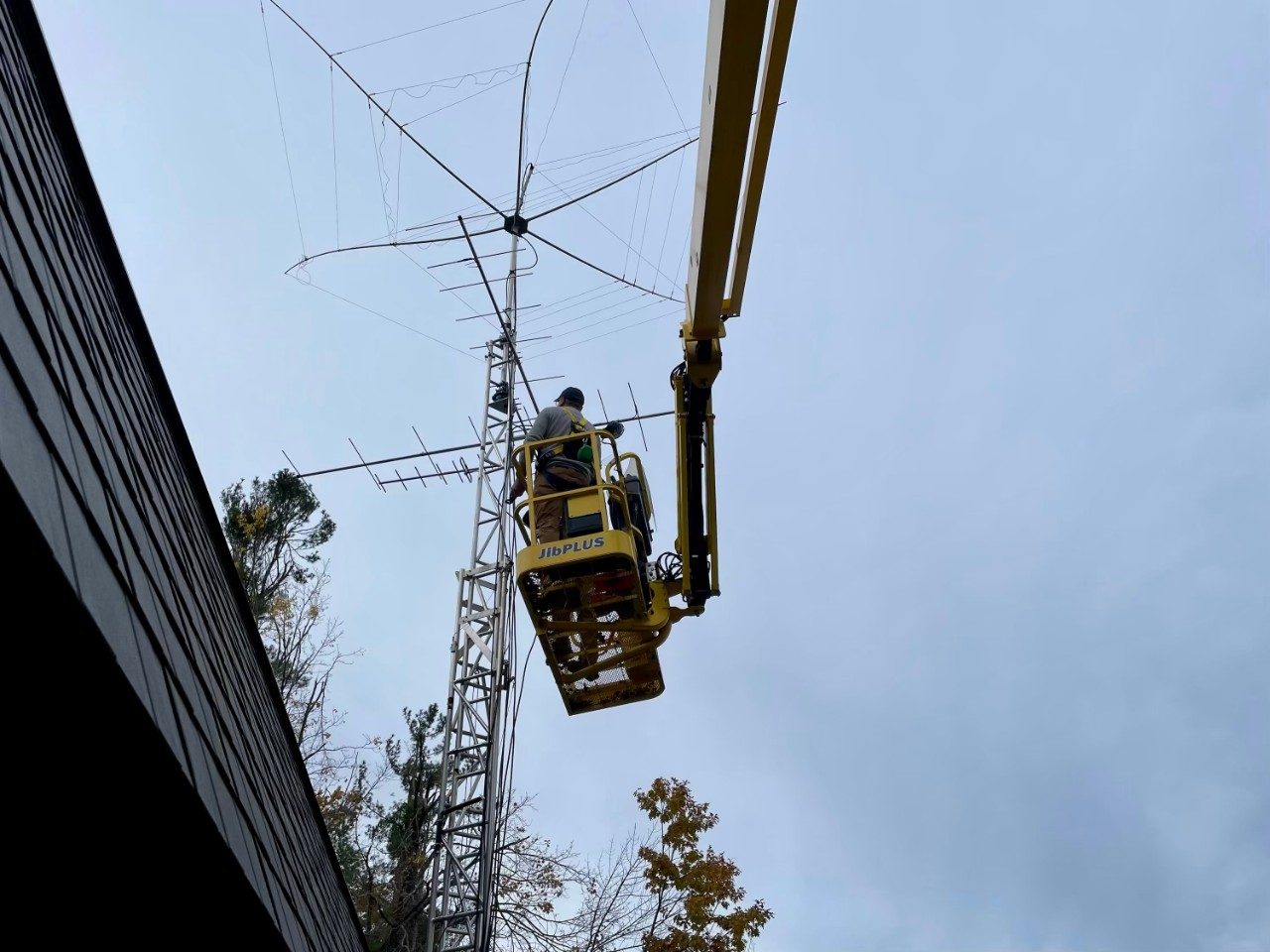 People on a lift machine installing an antenna on a tower