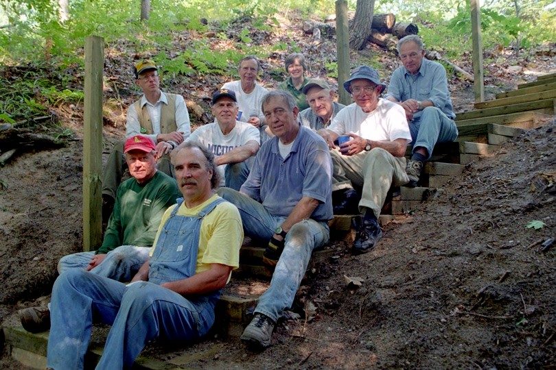 Group of people sitting on a stairway in a forest