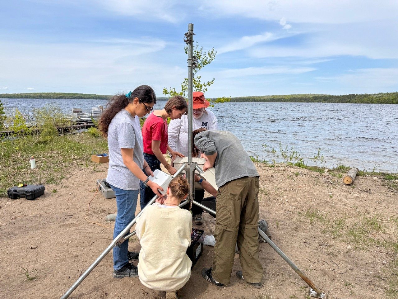 People building a tower along a lake