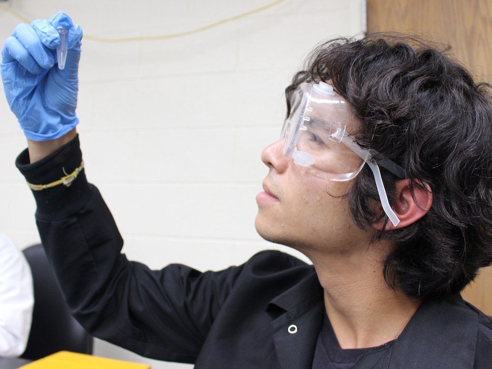 Person in lab holding scientific tool