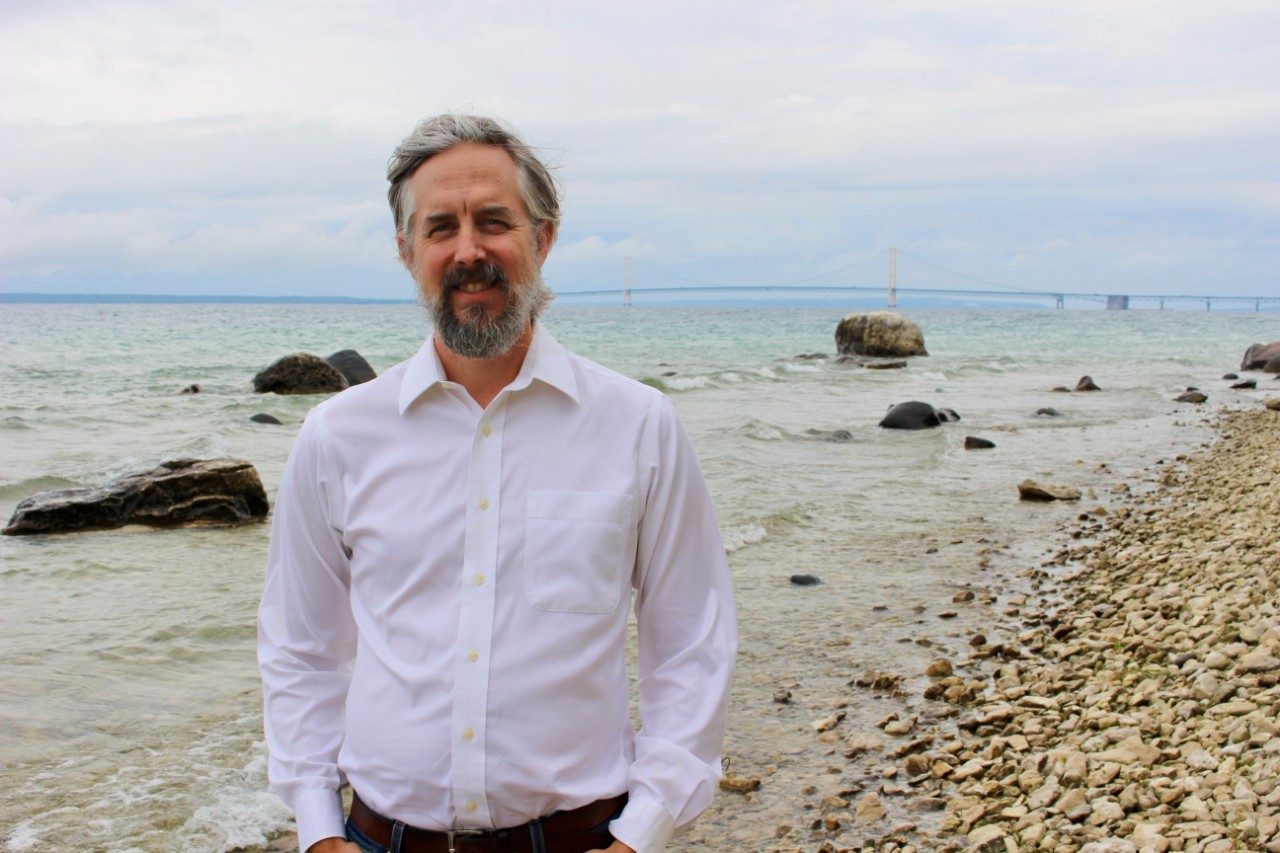 Man standing along a lakeshore