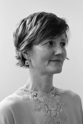 Professor Sweeney in a black and white photo looking to the right against a grey background