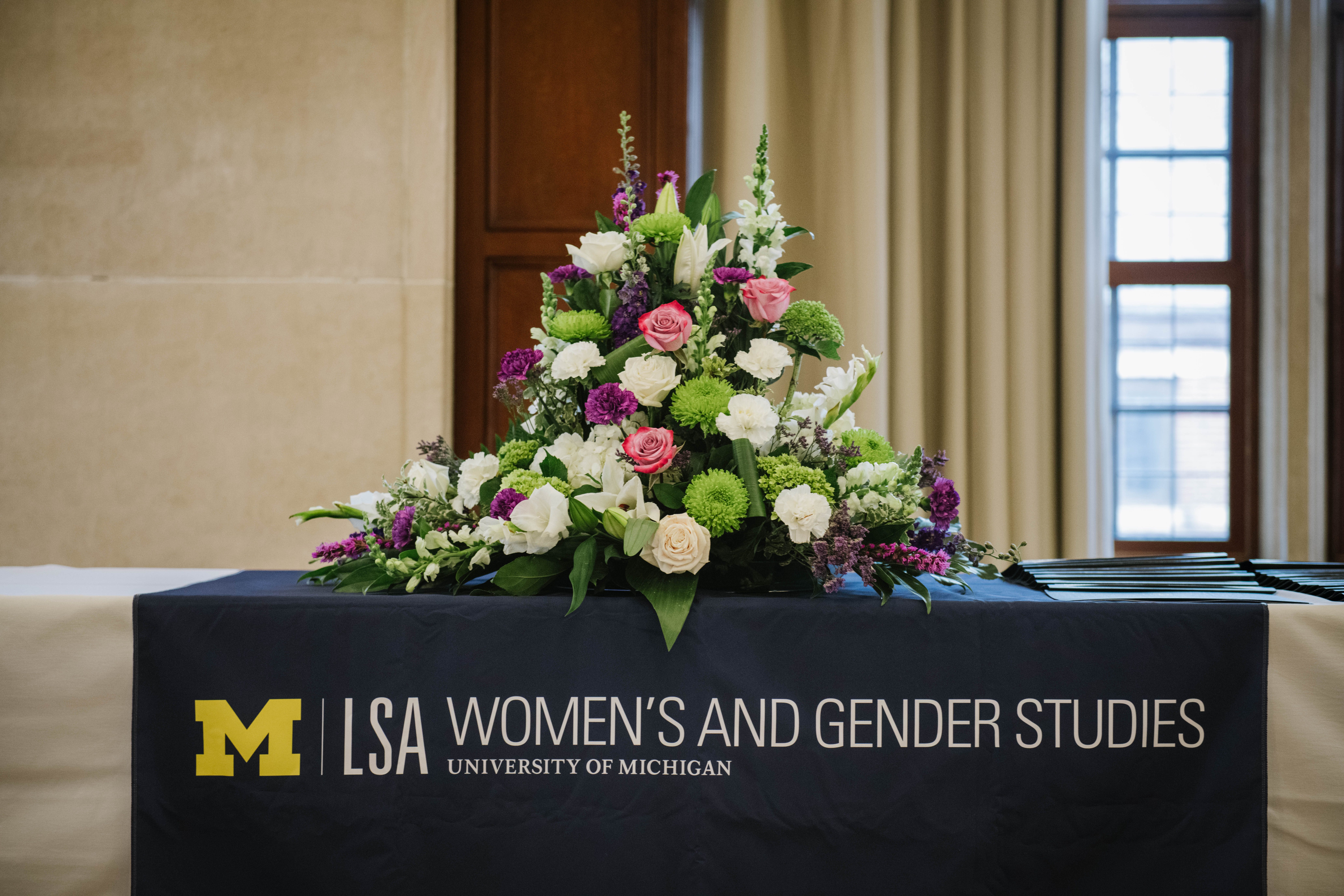 A floral arrangement sits on a table with a WGS tablecloth
