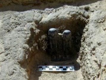 Votive statue of Intef and Ita. They stand in a shallow trench, with a measuring stick in front of them.