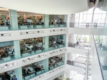 A photograph taken from across the atrium in the BSB of nine windows looking in on research.