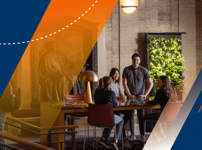 A group engages in a conversation around a table in the Angell Hall Living Room. 