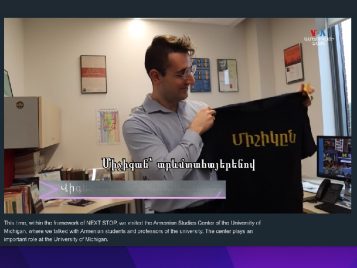 clip from the Voice of America video; Vicekn Moroudian holding a shirt with Michigan in Armenian script.