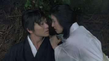 A man and a woman wearing kimonos stare intently at each other