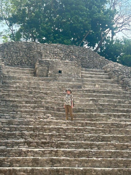 Humphrey standing on the steps about 1/3 of the way up a Mayan temple.