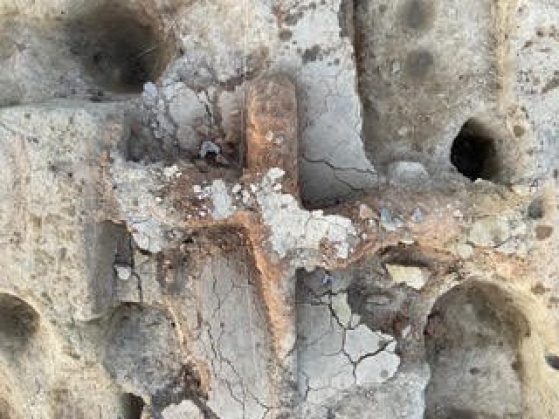 A close-up of a partially exposed artifact made of stone.