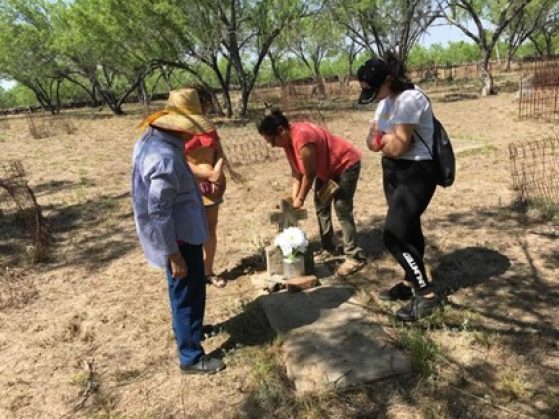 Four women visiting a grave.