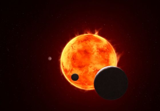 The Earth-size exoplanet TRAPPIST-1 e, depicted at the lower right, is silhouetted as it passes in front of its flaring host star in this artist’s concept of the TRAPPIST-1 system.