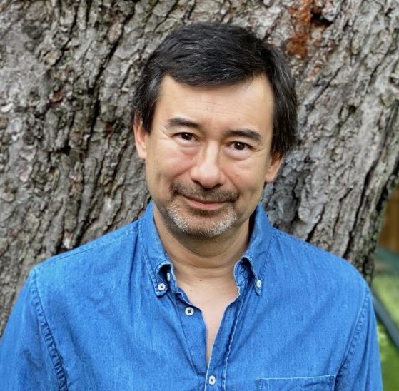 Headshot of Peter Ho Davies in blue shirt in front of tree
