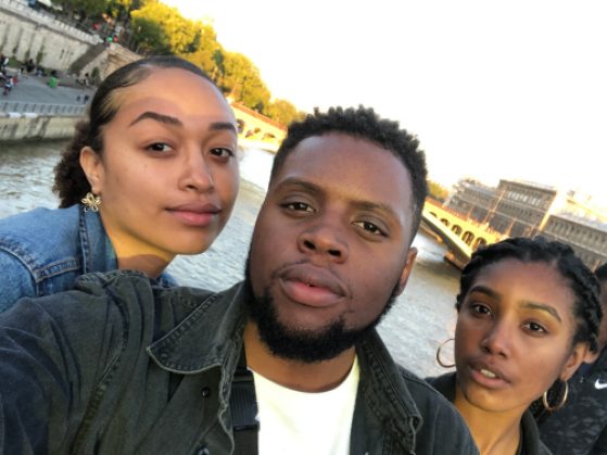 Three students pose for a selfie in front of a river in Paris.