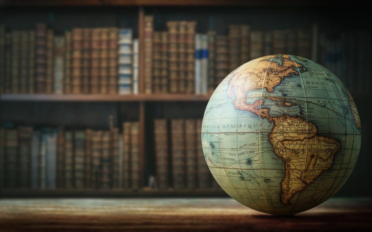 Globe with bookshelf in background with text, “What is Comparative Literature? We are an interdisciplinary field of study of literatures and cultures across borders of language, geography and time. Comparative Literature = Global Humanities.”