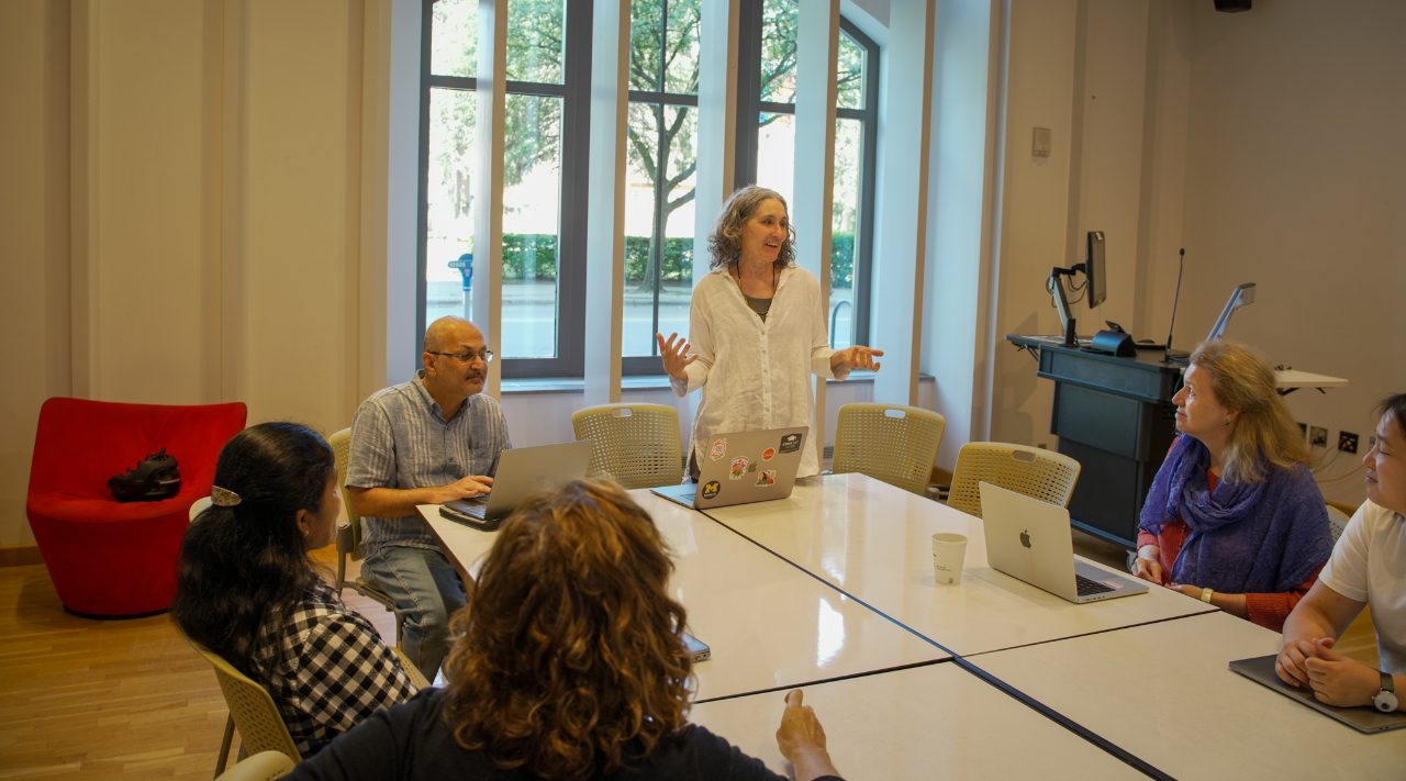 Dr. Christi Merrill meets with colleagues to discuss her novel use of AI in literature translation.