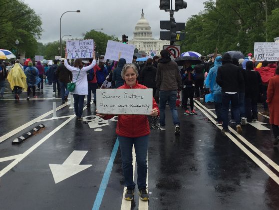 Priscilla Tucker showed up for the March for Science in Washington, D.C. She's holding a sign that says Science Matters. Ask me about biodiversity with the Capitol in the background and many people walking behind her