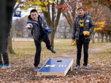 Two participants playing corn holes