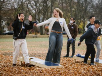 Participants playing cornhole game