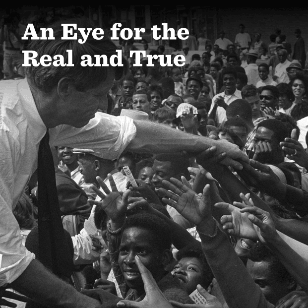 In this black-and-white photo, Presidential candidate Bobby Kennedy leans in to a crowd of hundreds of people, mostly people of color, in Detroit, reaching forward to shake hands during a campaign stop. He is wearing shirt sleeves and sports a slight smile. In the foreground this text: An Eye for the Real and True.