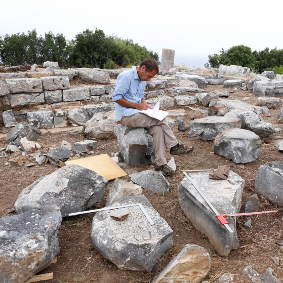 LSA Professor Christopher Ratte (sitting down and wearing a blue shirt) at site where he and his team discovered Persian gold coins