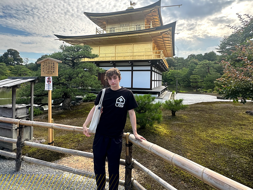 A student stands in front of a temple in Kyoto.