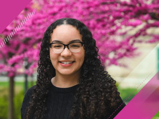 Photographic portrait of a student outside in front of a pink flowering tree