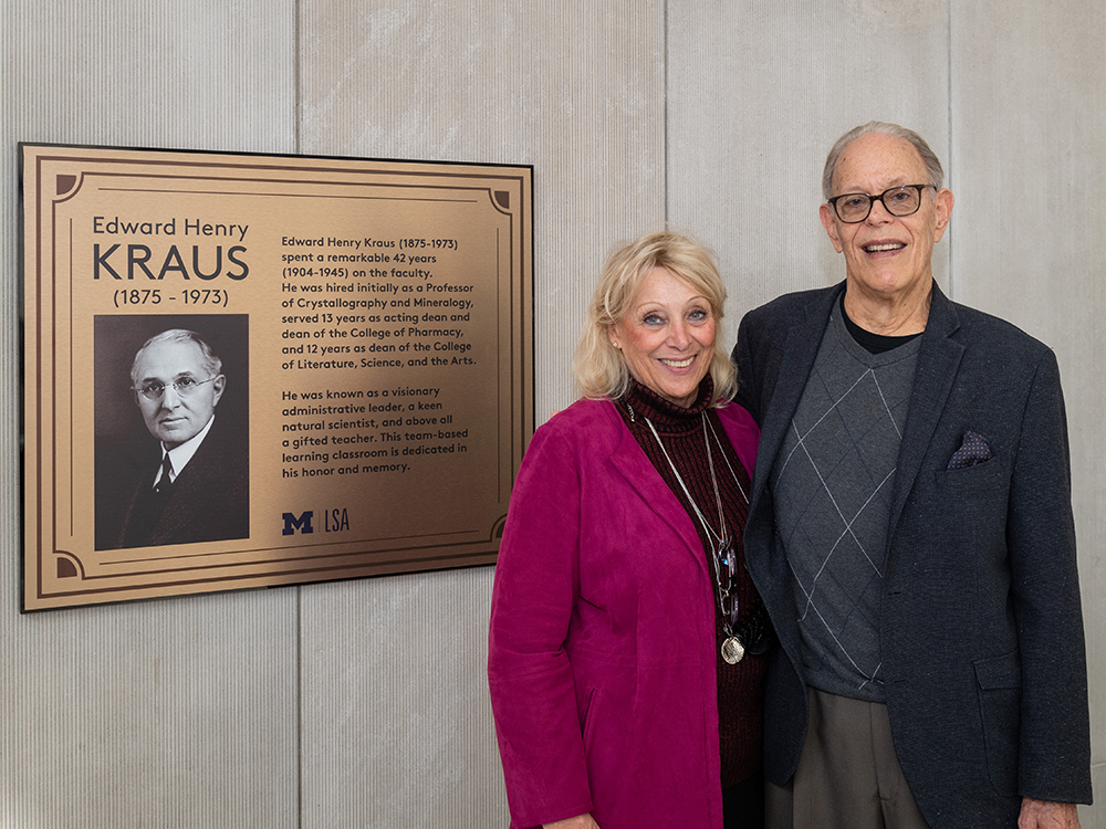 Nelson Kraus, with his wife, Susan Kraus, stand in front of his grandfather's plaque outside of Kraus Auditorium.