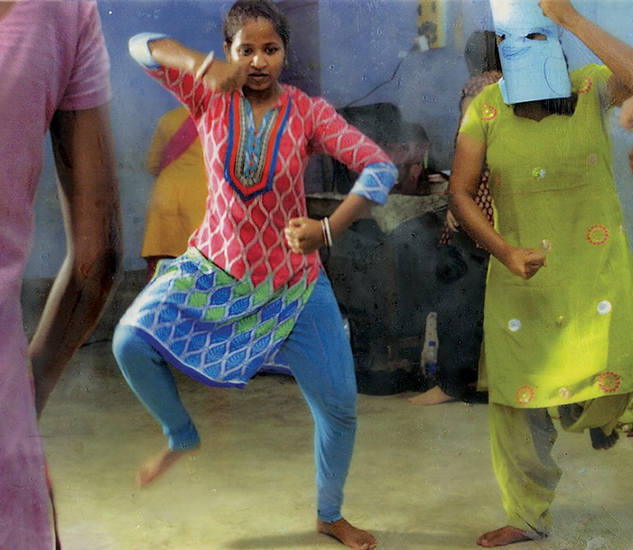 A scene from the documentary Little Stones that shows three girls stomping and dancing.