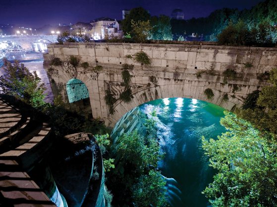 Photograph of the Tiber River flowing beneath an ancient arch. 