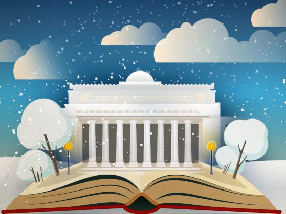 An open book before Angell Hall under a snowy sky.