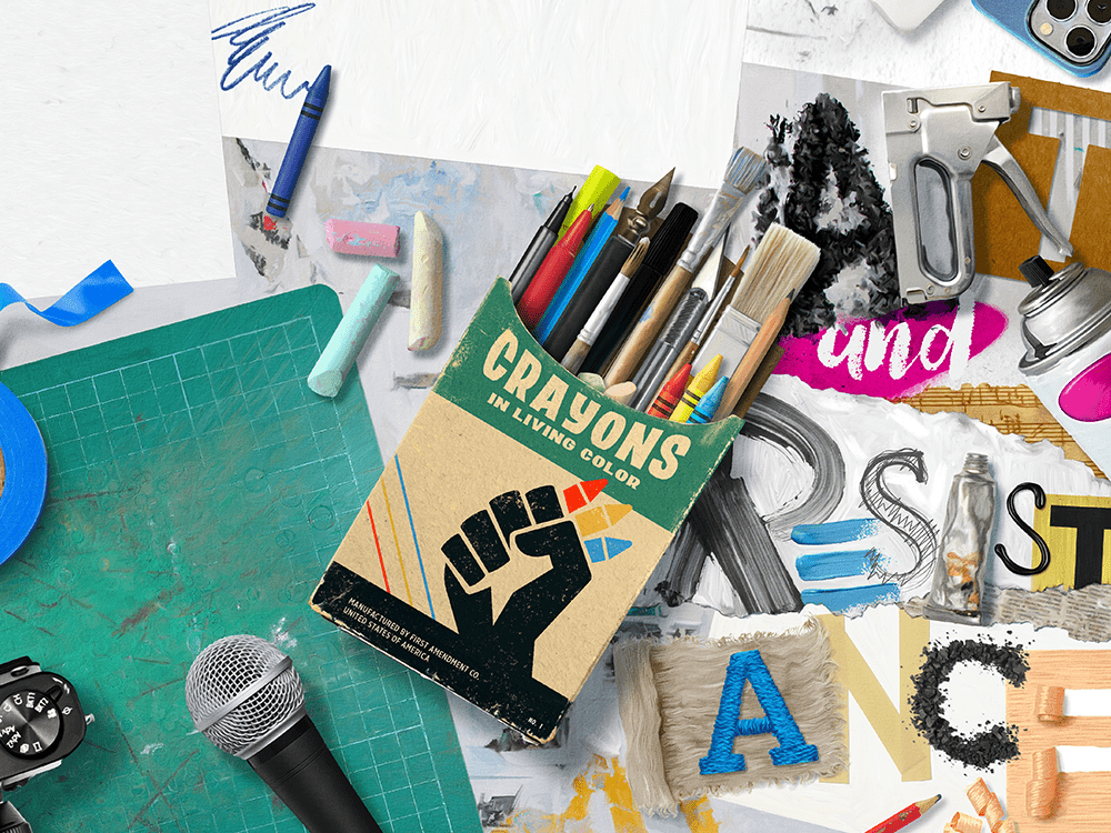 A collage of various styles of artwork spells out “art and resistance” using paint, torn paper, a staple gun, and other elements. A box of crayons is labeled “crayons in living color—manufactured by the First Amendment Co., United States of America” (with some of the text cut off at the bottom of the image). The box shows a fist holding crayons. The box holds crayons as well as paintbrushes and other art tools. The photo lens of a smartphone is visible at the top of the image. A cutting mat, a roll of blue painter’s tape, chalk, a microphone, and the controls from the top of an SLR camera make up the left side of the image