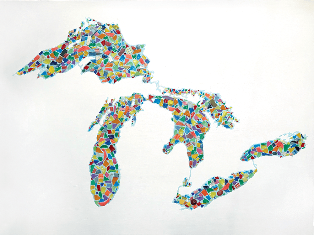 Against a white background, small, jagged pieces of plastic in various colors are arranged to look like the Great Lakes bordering Michigan’s Upper and Lower peninsulas.