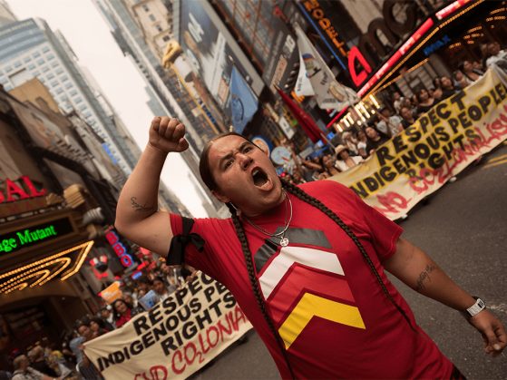 A member of an Indigenous community raises their fist during the People’s Climate March