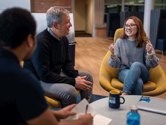 Students and alumni talk informally at the Hub.