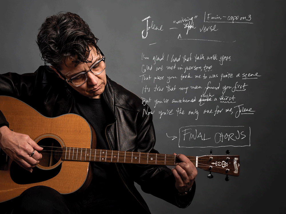 Nadine Hubbs with her guitar and the lyrics to a fourth verse she wrote for Dolly Parton's "Jolene."