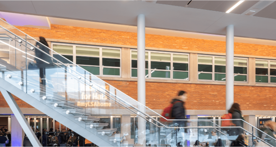 Interior view of the new LSA Building addition with students ascending and descending the central staircase.