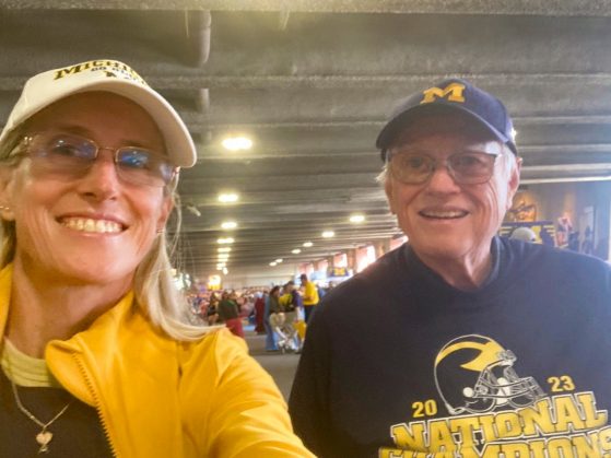 A photograph of a woman and a man at a University of Michigan football game.