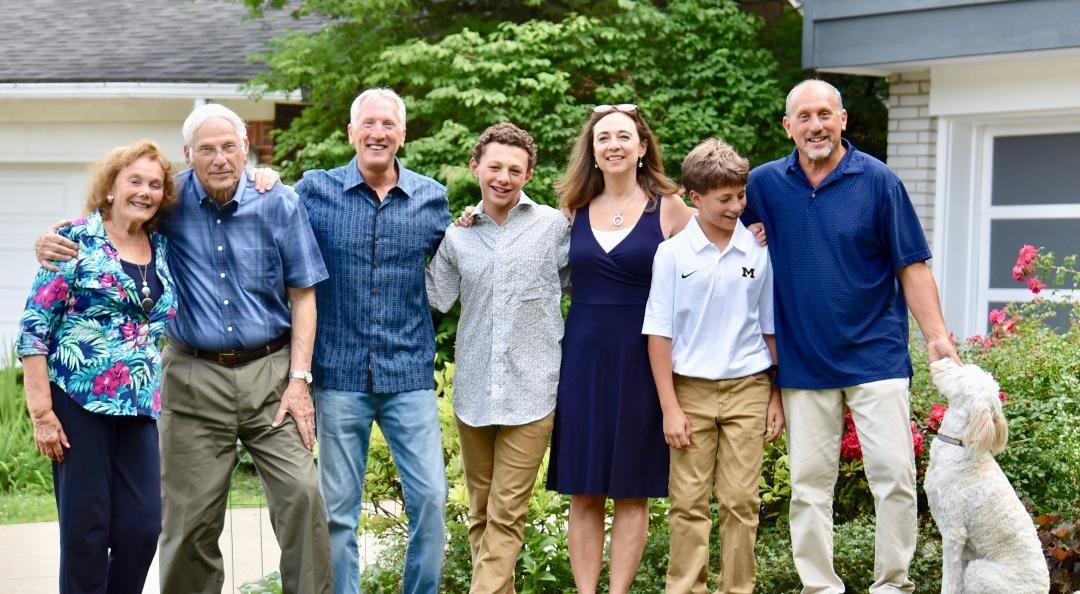 The Barbara and Al Cain family in the front yard of their Ann Arbor home: Barbara, Al, Steve, Sam, Susan, Eli, and Ken Cain, and the family dog.