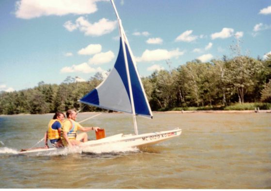 Cathy and Brian sailing a small boat across Douglas Lake.