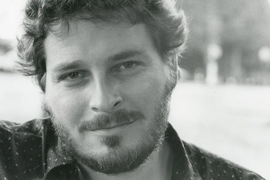 Black and white portrait of a man with short hair and a mustache and beard